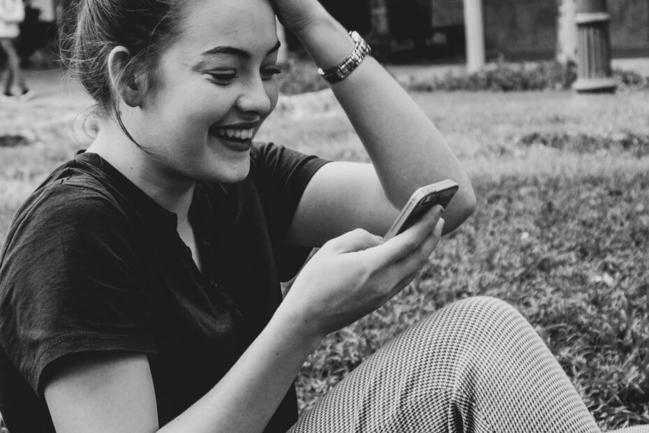 Girl laughing while looking at her phone.